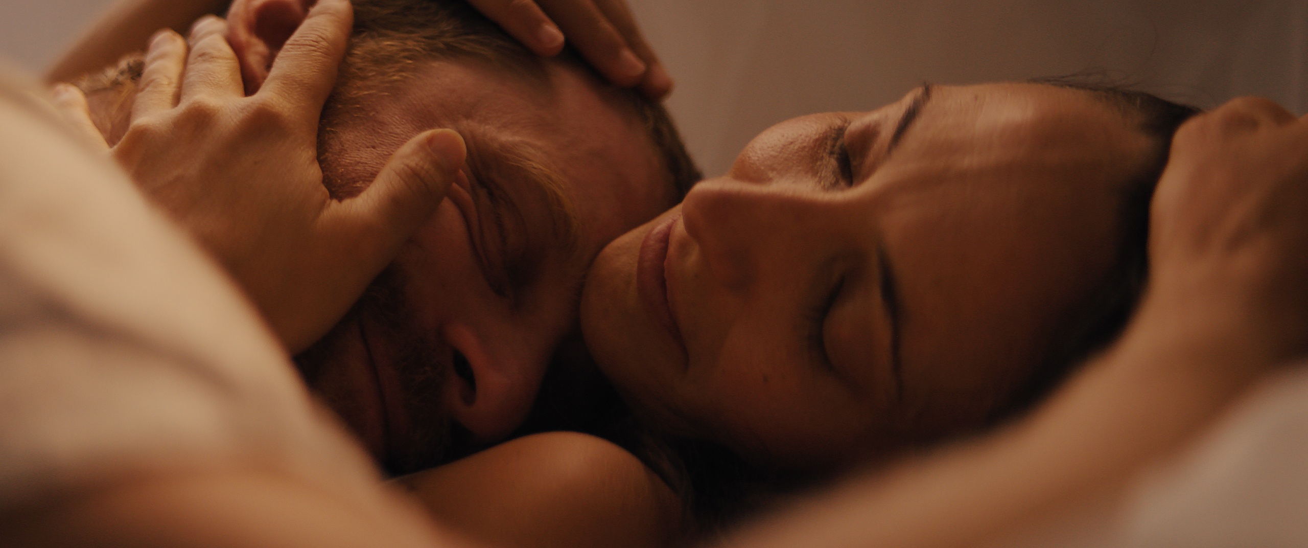 The Golden Hour — Lucia and Colin lying together, an intimate close-up, film still written and directed by Zane Ra